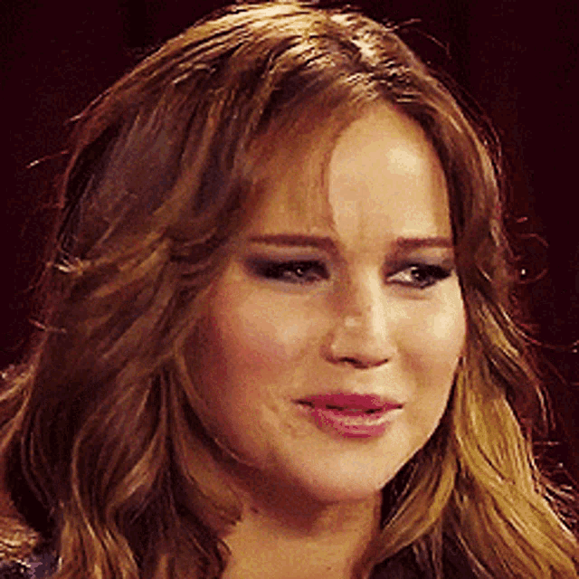a woman with long brown hair is making a sad face
