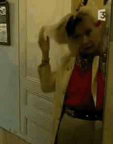 a woman standing in front of a door with the number 3 on it .