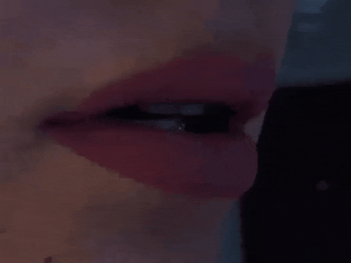 a woman is holding a black object in her mouth .