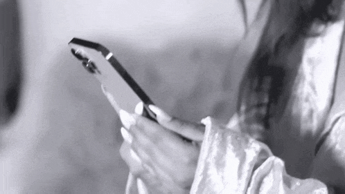 a woman is holding a cell phone in her hands .