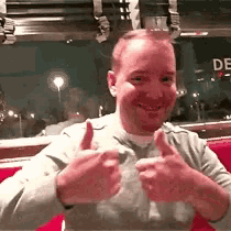 a man is giving a thumbs up in a diner at night .