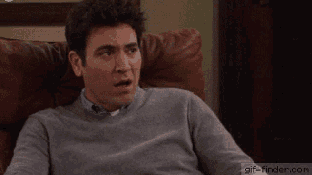 a man sitting on a couch with a gif-finder.com watermark