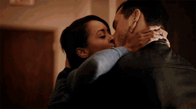 a man and woman are hugging and kissing in a room