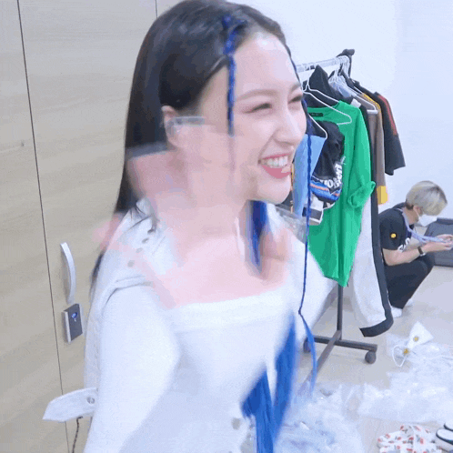 a woman with blue braids in her hair is smiling