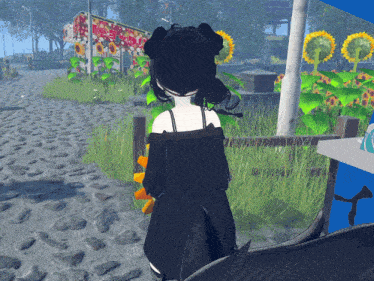 a girl in a black dress is standing in front of a fence with sunflowers in the background
