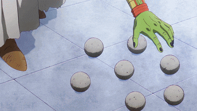 a green hand with black nails is reaching for some rocks on a tiled floor