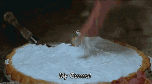 a person is cutting a pie with whipped cream on top and says `` my germs '' .