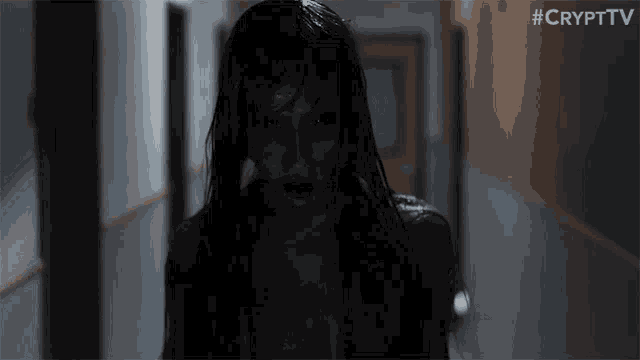 a scary woman is walking down a hallway with #crypttv written on the bottom right