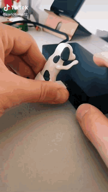a tiktok video of a person holding a clay dog