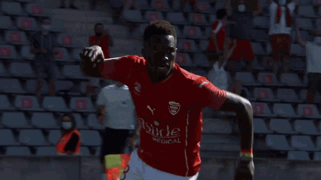 a soccer player wearing a red shirt that says stade