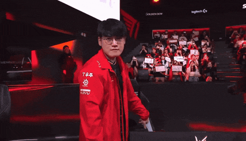 a man wearing glasses and a red jacket with a mercedes logo on it