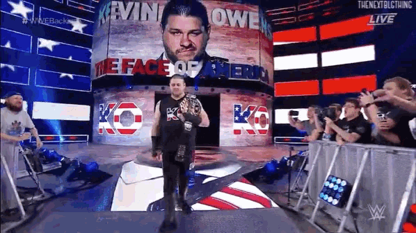 kevin owen is holding a wrestling championship while walking on the stage