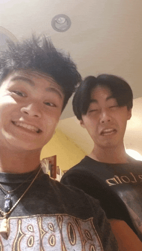 two young men posing for a picture one wearing a t-shirt that says circle
