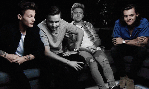 a group of young men are posing for a picture while sitting on a couch