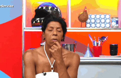 a shirtless man is sitting in front of a shelf with the word service on it