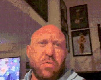 a bald man with a beard is making a funny face in a living room