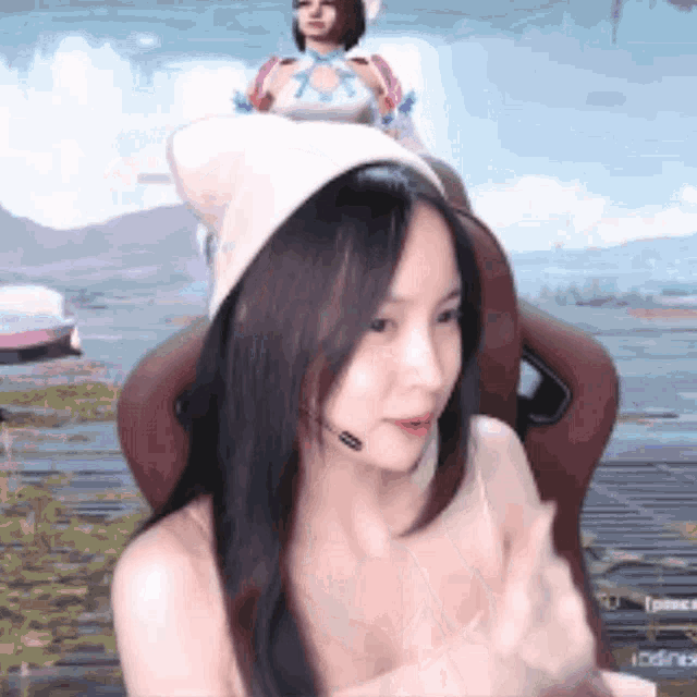 a woman wearing a white hat is sitting in a chair with a microphone on her head