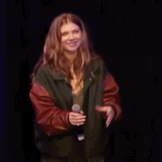a woman is holding a microphone on a stage .