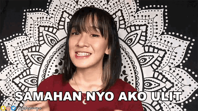a woman is smiling in front of a tapestry that says samahan nyo ako ulit on it
