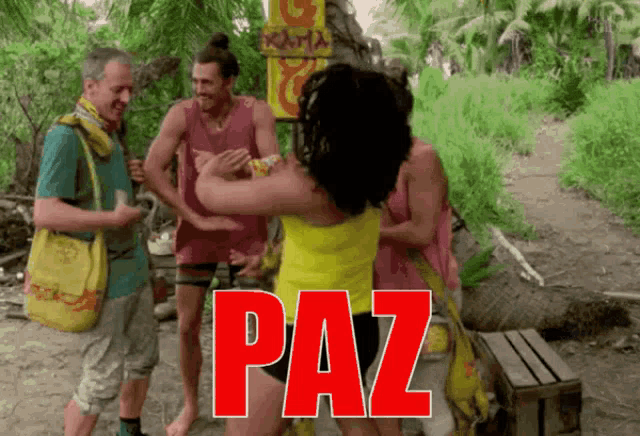a woman in a yellow shirt is hugging a group of people with the word paz written in red