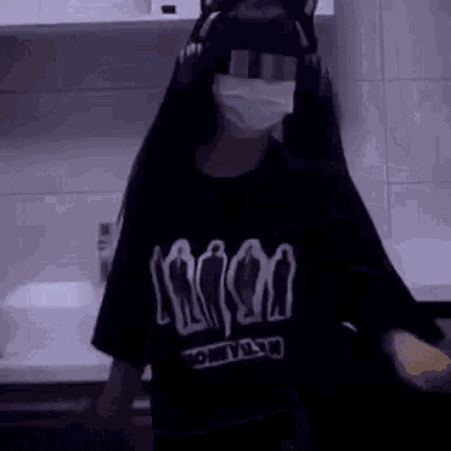 a girl wearing a cat ear headband and a mask is standing in a kitchen .