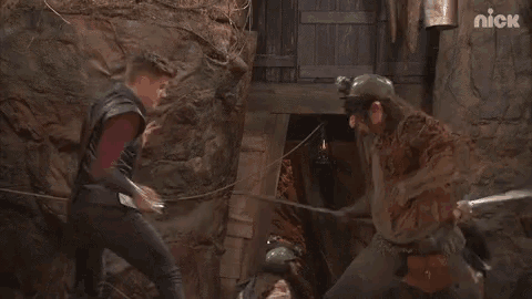 two men are fighting in a cave with nick in the background