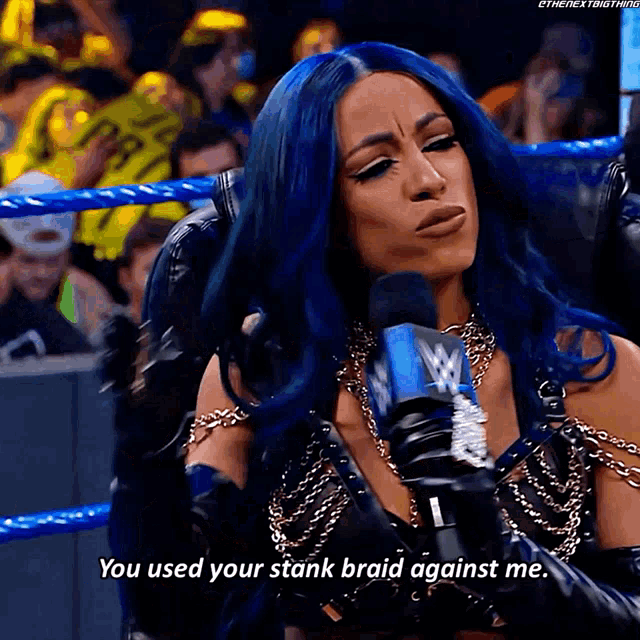 a woman with blue hair is talking into a microphone and saying you used your stank braid against me