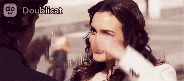 a woman is making a funny face while talking to a man and the words doublecat are above her