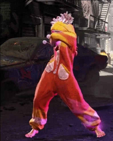 a person in a clown costume is dancing in front of a graffiti wall