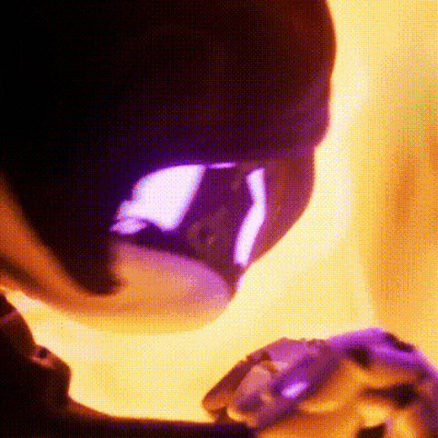 a close up of a person 's face with a purple light coming out of it .
