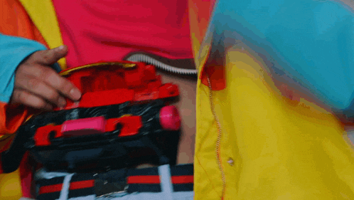 a person wearing a colorful jacket is holding a toy car