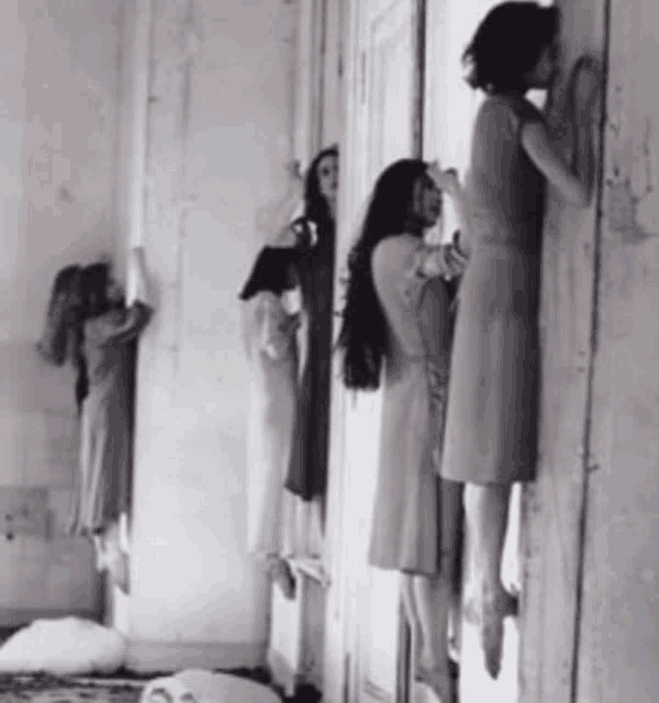 a black and white photo of a group of women leaning against a wall .