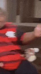 a fat man wearing a red and black striped shirt with the letter r on it .