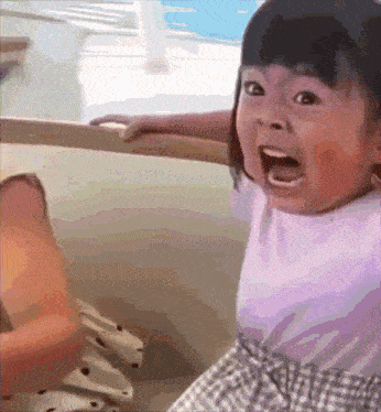 a little girl is making a surprised face with her mouth open