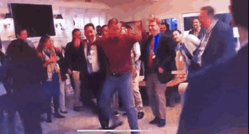 a man is dancing in front of a crowd of people .