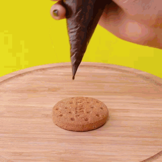 a person is decorating a cookie with chocolate