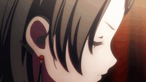 a close up of a girl 's ear with red earrings