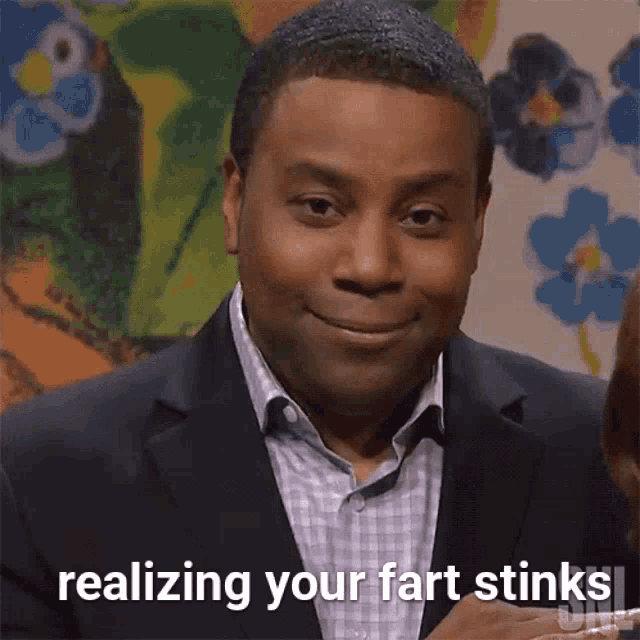 a man in a suit says " realizing your fart stinks " while making a funny face