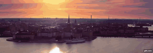 an aerial view of a city and a body of water at sunset .