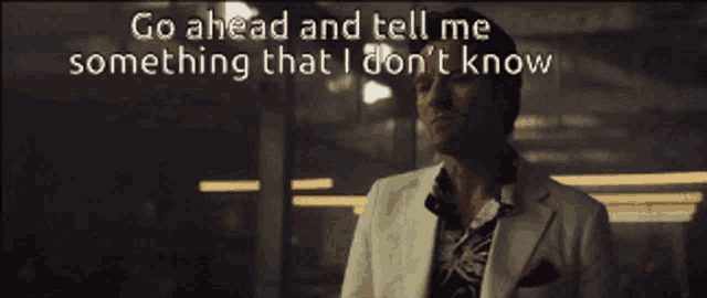 a man in a white suit says go ahead and tell me something that i don t know