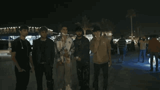 a group of young men standing next to each other in a parking lot