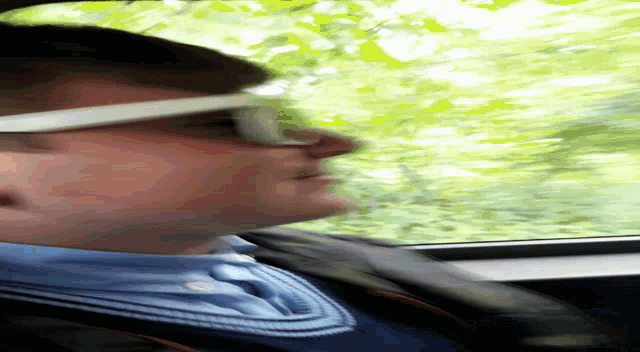 a man wearing sunglasses is looking out of a window
