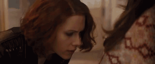 a close up of a woman looking at another woman 's face in a room .