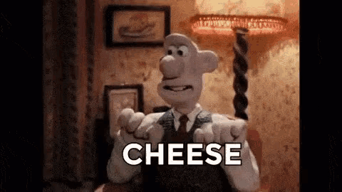 a cartoon character is holding a piece of cheese in his hand .