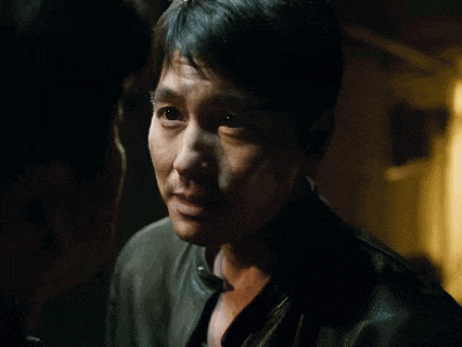 a man in a black jacket looks at another man