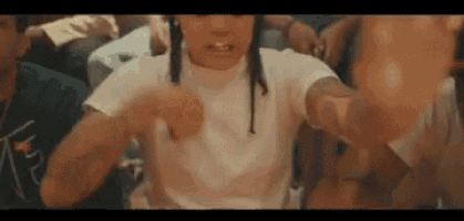 a group of people are dancing in a room and a woman is giving a middle finger .