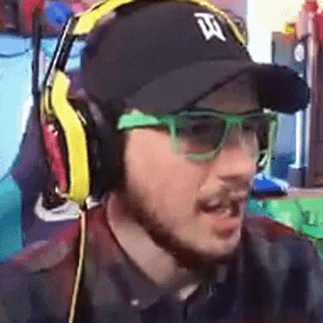 a man wearing headphones and a hat with a letter t on it .