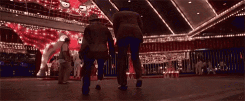 a couple of people walking in a dark room with a sign that says ' a ' on it