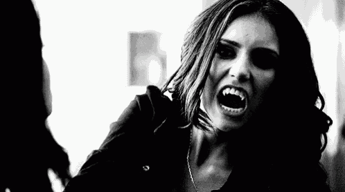 a black and white photo of a woman screaming with her mouth open .