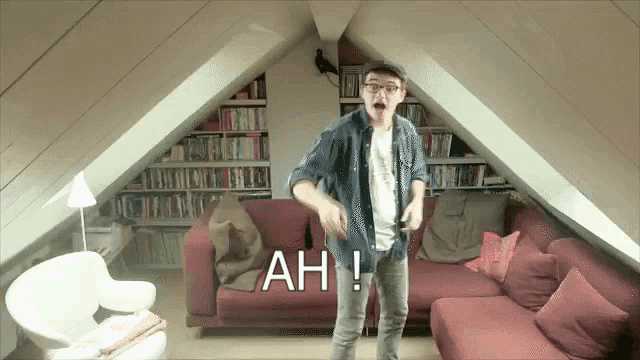 a man is dancing in a living room with ah written on the bottom right